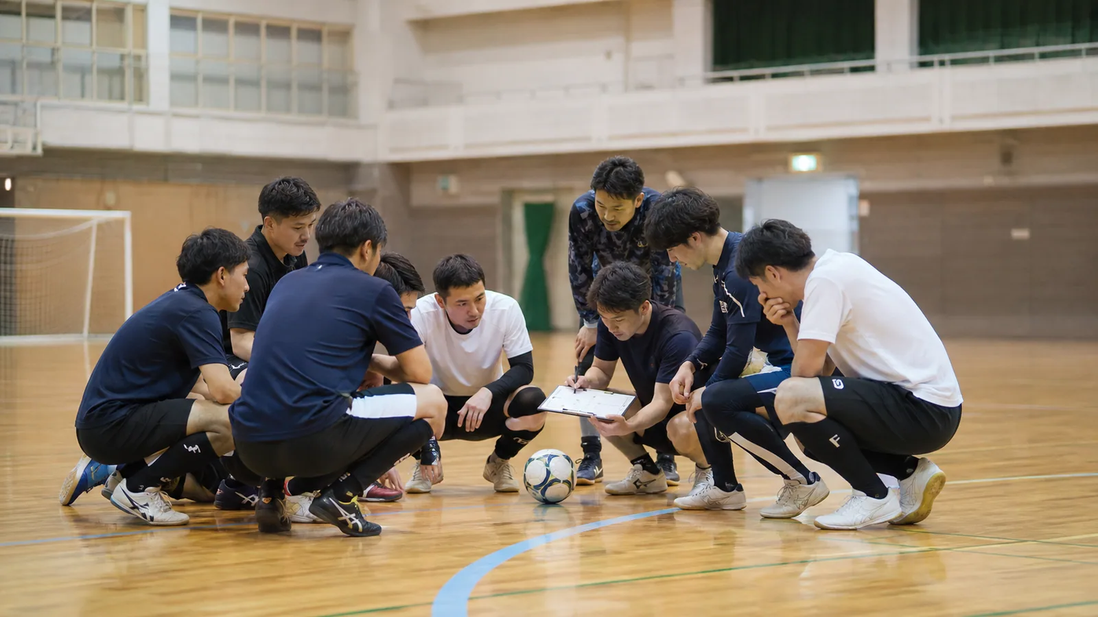 体育館で新規参入に向けた準備を話し合うフットサルチーム